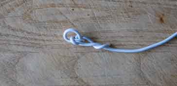 Tie a knot int he end of the wire at the end of the dipole to enable string or twine to be attached