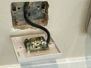 The wiring behind a TV socket wallplate